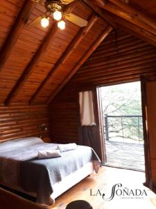 a bedroom with a bed and a large window at La Soñada Cabañas & Spa in Merlo