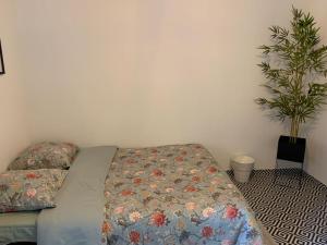 a bed with a floral comforter in a bedroom at Studio VI proche ligne 14 Kremlin Bicêtre in Arcueil