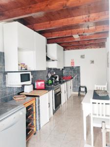 uma cozinha com armários brancos e uma bancada em Casa d'Avó na Carrapateira