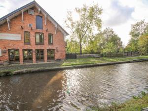 a building next to a river next to a building at The Grain Store in Nantwich