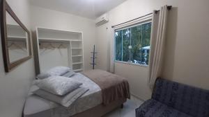 sypialnia z łóżkiem, oknem i krzesłem w obiekcie Pousada 4 Estações Campeche w mieście Florianópolis