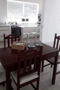 cocina con mesa de madera, sillas, mesa y mesa en Casa kukycita en San Salvador de Jujuy