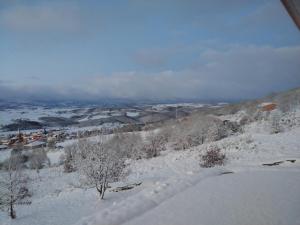 a snow covered hill with a town in the distance at Naudebals in Rebourguil