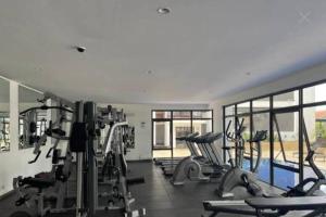 a gym with several treadmills and elliptical machines at Astoria 2BR Penthouse [Views of Bliss] in Nairobi