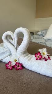 Dos cisnes hechos de toallas en una cama en Suites Carioca en Porto de Galinhas