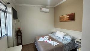 Habitación pequeña con cama y toallas. en Suites Carioca en Porto de Galinhas