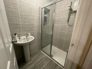La salle de bains est pourvue d'un lavabo et d'une douche en verre. dans l'établissement The Oxford Avenue, à Southampton