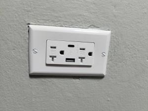 um interruptor de luz no lado de uma parede em In-flight Suites - Perfect for Layovers 6Mins from the Airport em Piarco