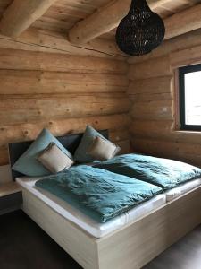 a bed in a room with a wooden wall at Ferienhof Weisser Hirsch in Werben
