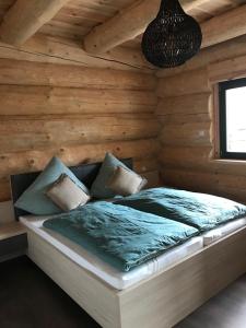 Cama en habitación con pared de madera en Ferienhof Weisser Hirsch en Werben