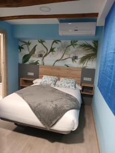 1 dormitorio con 1 cama y una pintura en la pared en Hostal Platerías, en León
