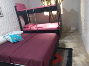 a bedroom with two bunk beds with pink sheets at Cabaña El Tucan in Minca