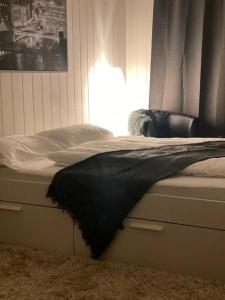 a bed with a black blanket on top of it at Cosy Studio in Kempen in Kempen