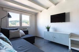 サンシェンショにあるApartamento Sanxenxo Centroのソファ付きのベッドルーム1室、壁にテレビが備わります。