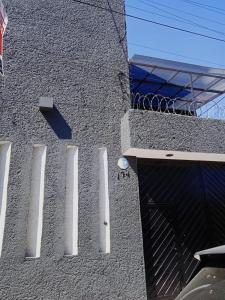 um edifício cinzento com uma porta e uma janela em Alojamiento GAMA em Cidade do México