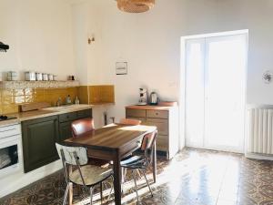 Gîte de la Bastide في Autignac: مطبخ مع طاولة وكراسي خشبية