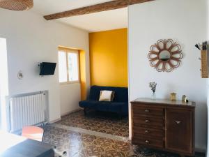 Gîte de la Bastide في Autignac: غرفة معيشة مع أريكة زرقاء وكرسي