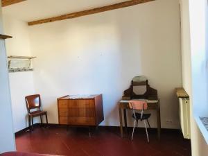an empty room with a desk and two chairs at Gîte de la Bastide in Autignac