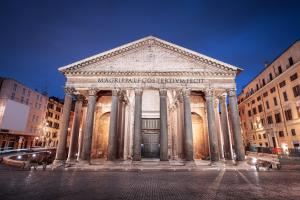 a building with columns in a city at night at Rome city center in Rome
