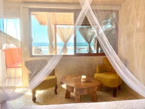 Zimmer mit einem Fenster mit einem Tisch und einem Stuhl in der Unterkunft Casa de las Olas Surf & Beach Club in Acapulco