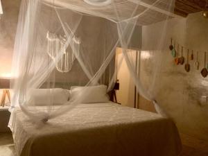 1 dormitorio con cama con dosel y cortinas blancas en Casa de las Olas Surf & Beach Club en Acapulco