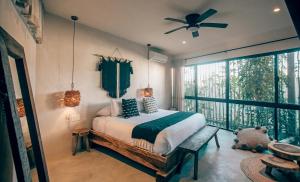 a bedroom with a bed and a ceiling fan at Vida Jungle Apart 7 with special fee to access Hotel Bardo in Tulum