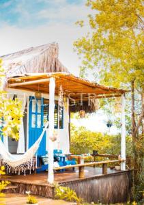 une maison avec un hamac sur une terrasse dans l'établissement Eco-Pousada Casa Bobô, à Île de Boipeba