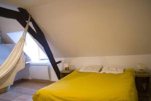 sypialnia z żółtym łóżkiem i oknem w obiekcie maison R&vâmes w Calais