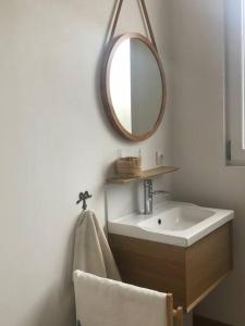 een badkamer met een wastafel en een spiegel aan de muur bij maison R&vâmes in Calais