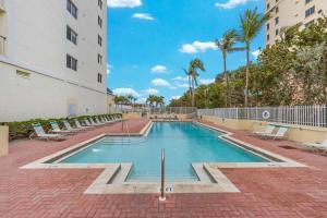 a swimming pool with chairs and a building at Apollo #210 in Marco Island