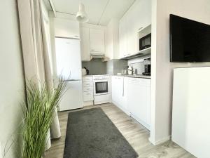 eine Küche mit weißen Schränken und einem schwarzen Teppich in der Unterkunft Tammer Huoneistot - City Suite 1 - Sauna, Balcony & Free parking in Tampere