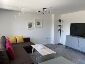 een woonkamer met een bank en een tv bij Paradigm House, Modern 2-Bedroom Duplex Apartment 2, Free Parking, Oxford in Oxford