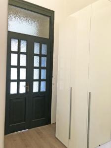 una stanza con una porta nera e armadi bianchi di Appartamento Il Gelsomino a Castelleone