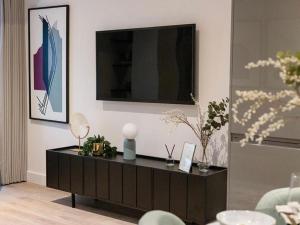 a living room with a black cabinet with a television on it at Luxury Modern, One bedroom flat in Solihull