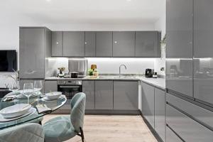 una cucina con elettrodomestici in acciaio inossidabile e tavolo in vetro di Luxury Modern, One bedroom flat a Solihull