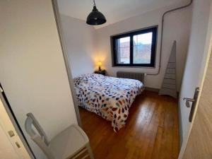 een kleine slaapkamer met een bed en een raam bij Gîte de charme à la ferme in Josnes