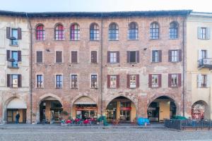 un gran edificio de ladrillo con muchas ventanas y mesas en Vittoria Suite, con Jacuzzi - by Host4U, en Pavia