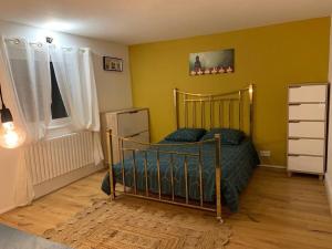 - une chambre avec un lit dans une pièce aux murs jaunes dans l'établissement Maison paisible Rennes sud avec jaccuzzi sur réservation, à Noyal-Châtillon-sur-Seich