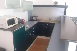 a small kitchen with a microwave and a counter at Maison avec jacuzzi proche Rennes jardin calme in Noyal-Châtillon-sur-Seich