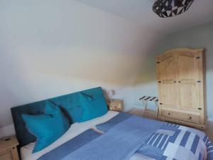 Schlafzimmer mit einem blauen Bett und einem Holzschrank in der Unterkunft Fewo Karasek in Oybin mit Panormablick, Kammlage in Hain