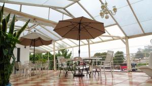 un patio con mesa, sillas y sombrillas en Hotel Jardines Del Carmen, en San Cristóbal de Las Casas