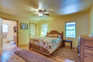 um quarto com uma cama e uma ventoinha de tecto em Pastoral Log Cabin with Trails about 1 Mi to Grand Lake em Fairland