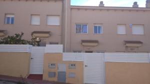 a white fence in front of a building at Fantástica casa con piscina y playa ,Torredembarra-Tarragona in Pobla de Montornés