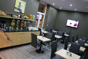 a restaurant with tables and chairs and a counter at Hotel Columbus in Frankfurt