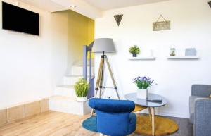 uma sala de estar com uma cadeira azul e uma mesa em Les Logis Poitevin - Maisons - Terrasses - Détente em Poitiers