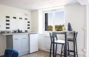 uma cozinha com mesa e cadeiras e uma janela em Les Logis Poitevin - Maisons - Terrasses - Détente em Poitiers