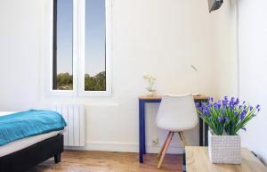 um quarto com uma secretária, uma cadeira e uma janela em Les Logis Poitevin - Maisons - Terrasses - Détente em Poitiers