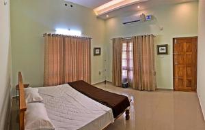 a bedroom with a bed and a window with curtains at Monappa Estate - Beautiful Riverside Farm house in Udupi in Udupi
