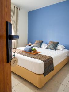 1 dormitorio con 1 cama con pared azul en Rumah Ijau - Halal Homestay, en Padangluar