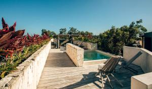 a swimming pool with a chair and a wooden deck at Vida Jungle Apart 7 with special fee to access Hotel Bardo in Tulum
